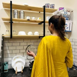 The girl is cooking in the kitchen of service apartment for corporates