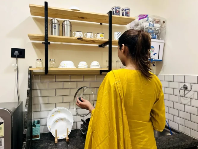 The girl is cooking in the kitchen of service apartment for corporates