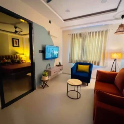 1BHK service apartment with modern living room, bedroom view, wall-mounted TV, and stylish furniture setup